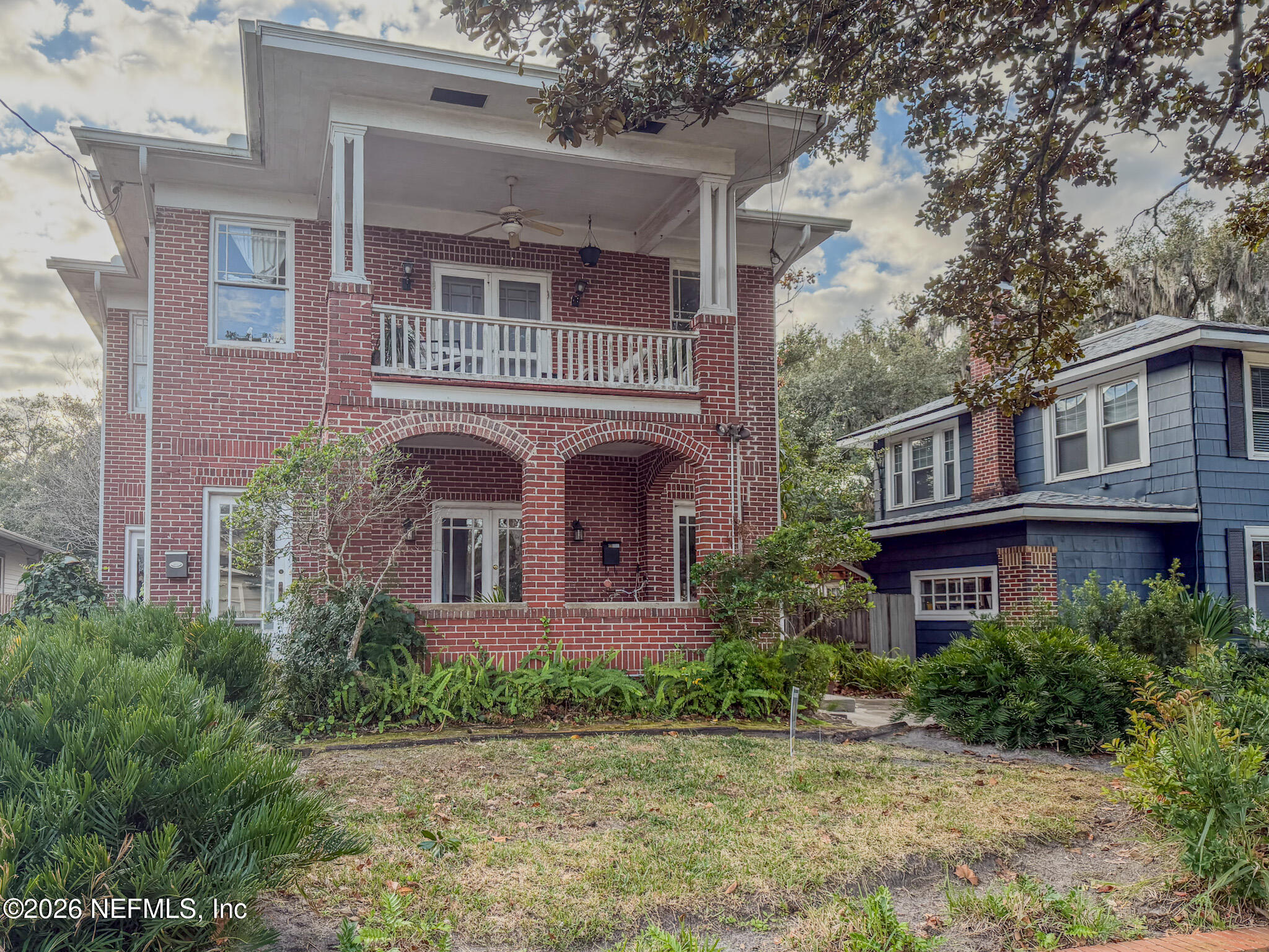 front view of a brick house with a yard