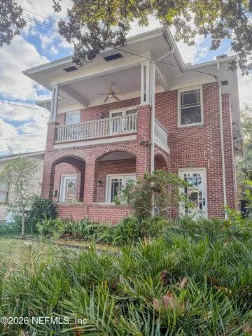 a front view of a house with plants and trees