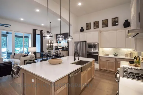 a kitchen that has a lot of cabinets in it and stainless steel appliances