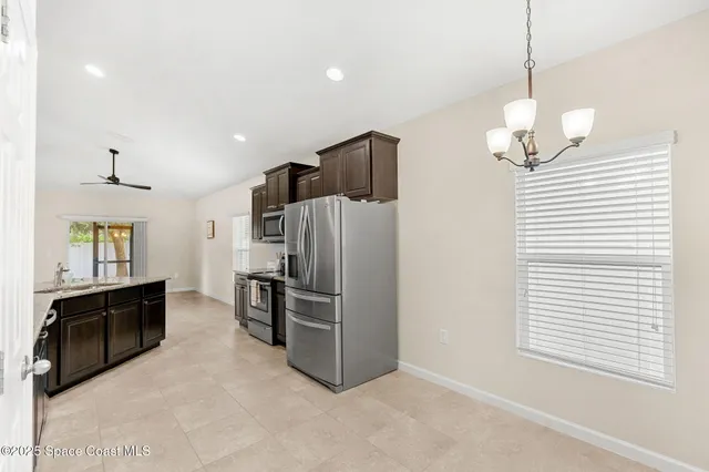 a view of kitchen with refrigerator cabinets and furniture