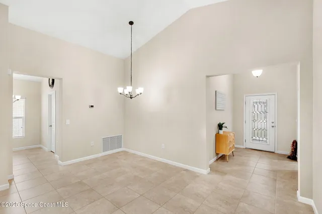 a view of a room with gym equipment and a chandelier