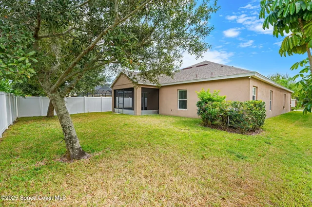 a view of a house with backyard and tree