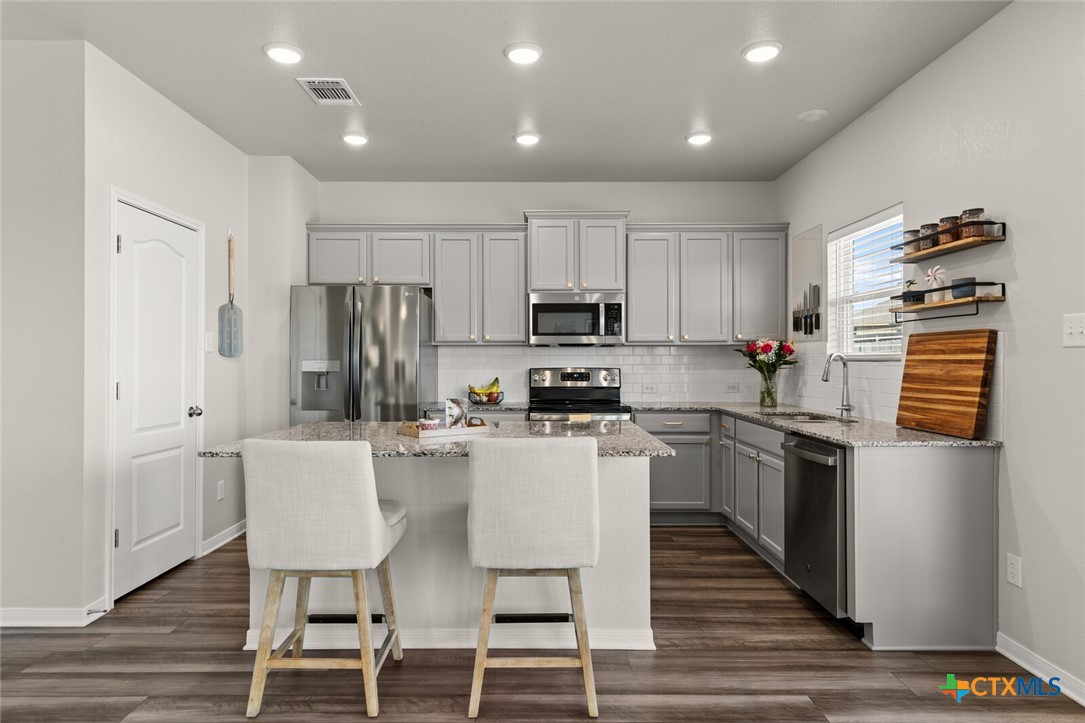 2233 Chia Court Temple, TX 76501 - Photo 15 of 47 a kitchen with kitchen island white cabinets and stainless steel appliances