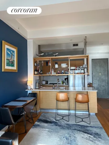 a living room with a table a table and kitchen view