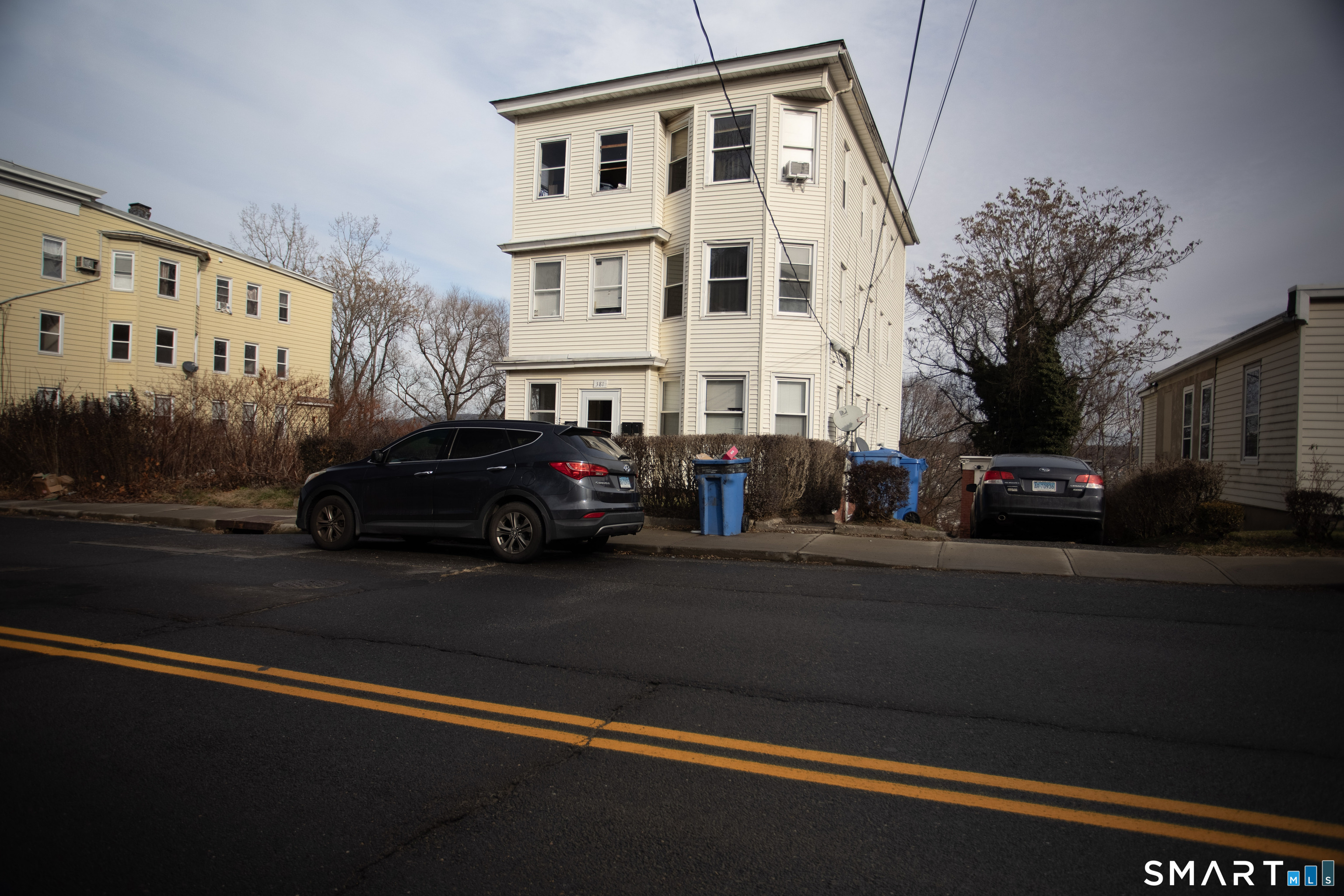 a view of a street that has couple of cars parked on the road