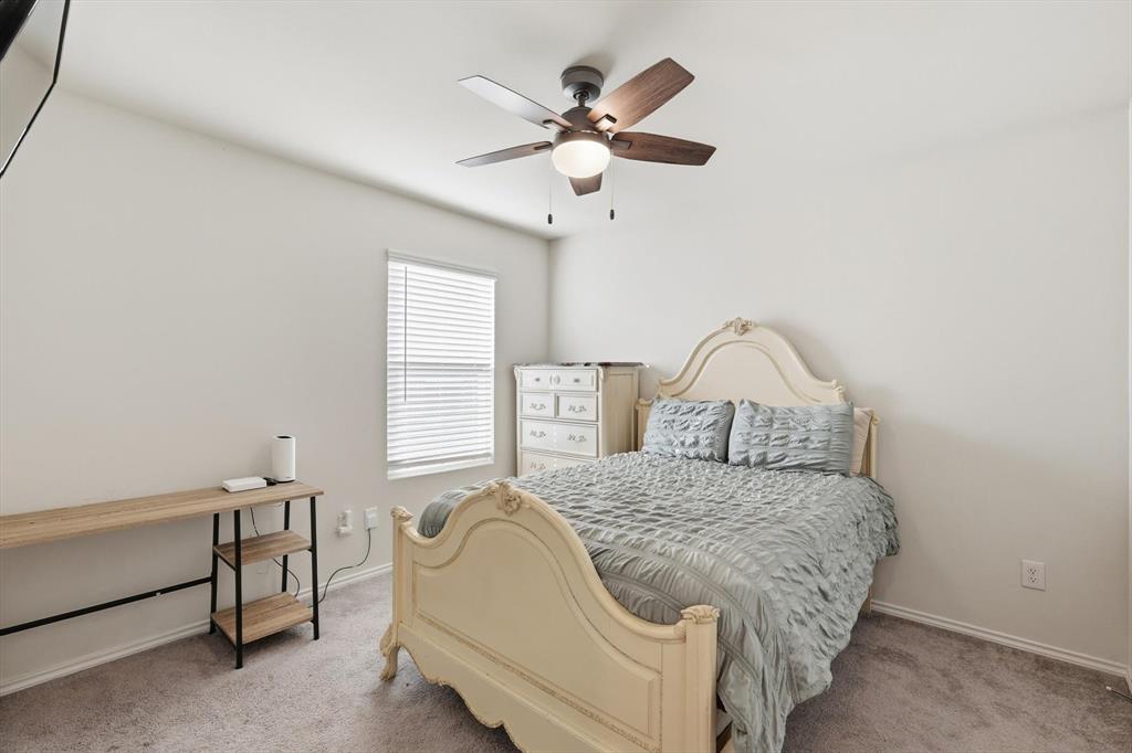 16041 Pious Drive Haslet, TX 76052 - Photo 20 of 36 a bedroom with a bed and a chandelier
