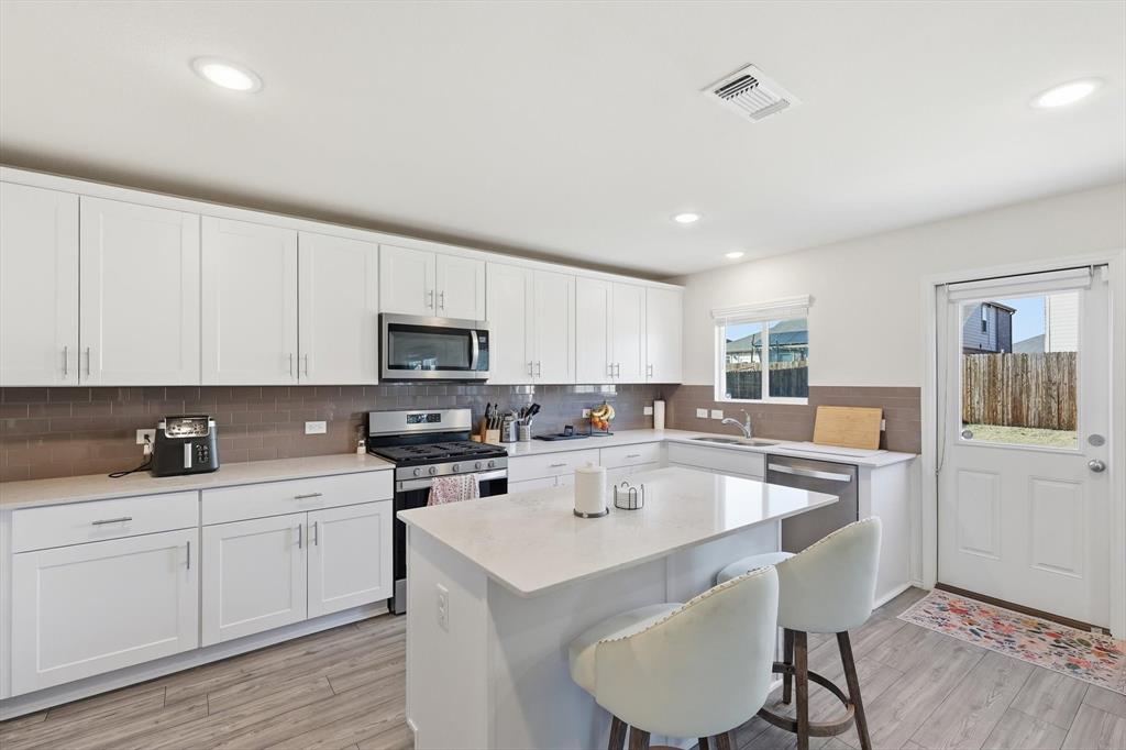 16041 Pious Drive Haslet, TX 76052 - Photo 6 of 36 a kitchen with a sink a microwave and cabinets