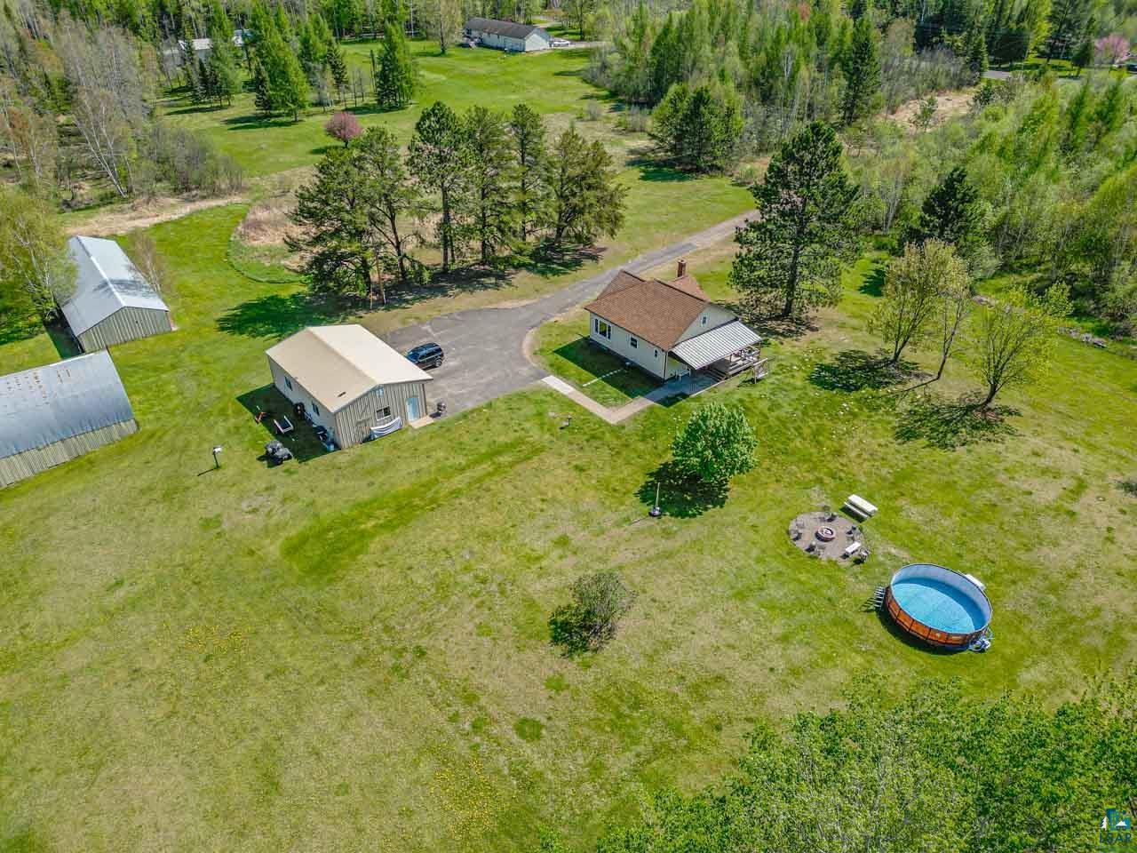 2581 O'Rourke Road Hibbing, MN 55746 - Photo 56 of 61 Property featuring a main residence with a covered porch, two additional outbuildings, and a gravel driveway