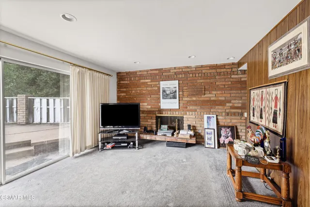 a view of a livingroom with workspace and a window