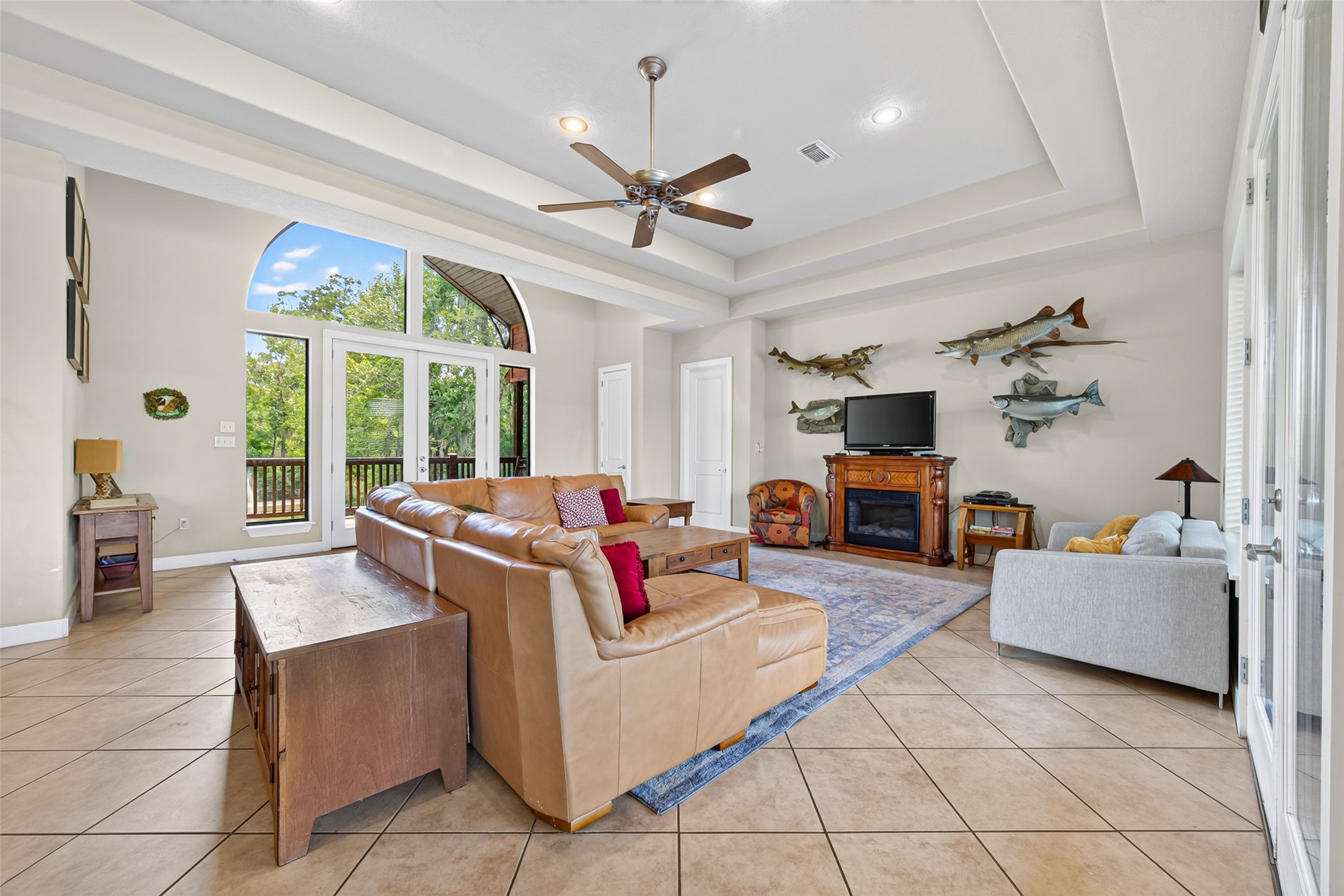 8 Smith Loop South Cleveland, TX 77327 - Photo 7 of 29 Spacious living room with vaulted ceilings, a cozy fireplace, and large windows offering serene views of the outdoors.