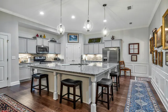 a kitchen with stainless steel appliances granite countertop a sink stove and refrigerator