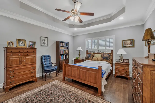 a bedroom with a bed table and a flat screen tv