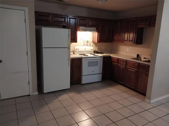 a kitchen with a refrigerator sink and cabinets