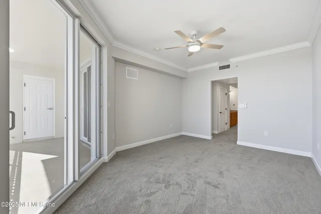an empty room with a window and a ceiling fan