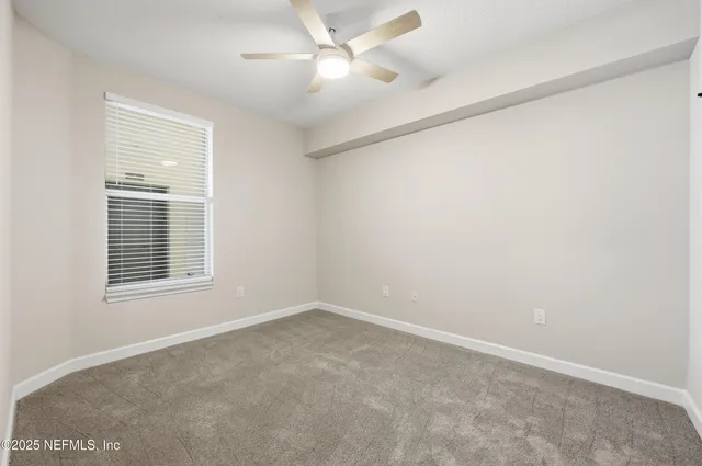 an empty room with a ceiling fan and closet
