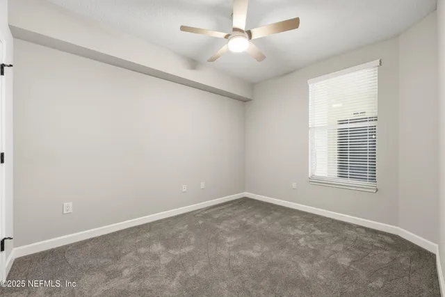 an empty room with a ceiling fan and a fan