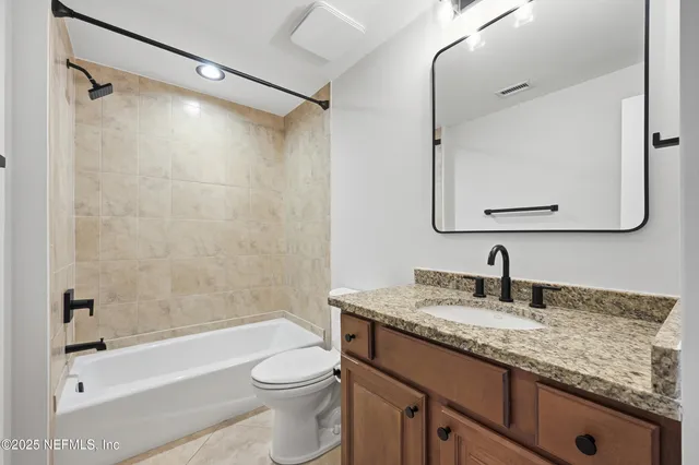 a spacious bathroom with a tub sink and mirror