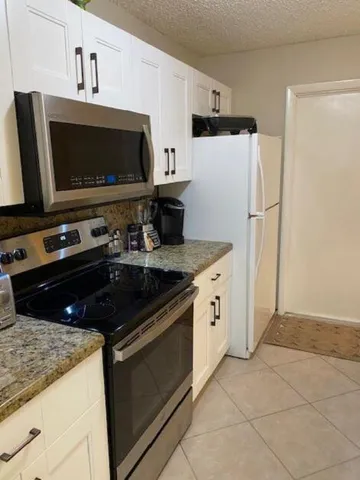 a kitchen with stainless steel appliances a stove microwave and refrigerator