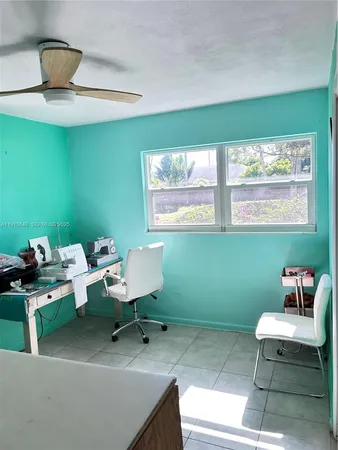 a view of a backyard with chair and potted plants