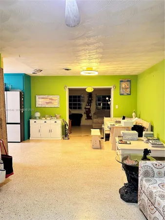 a living room with couches a flat screen tv and kitchen view