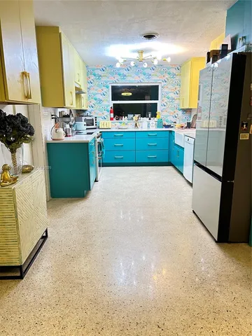 a kitchen with stainless steel appliances a sink and a refrigerator