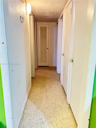 view of a hallway with wooden floor and a bathroom