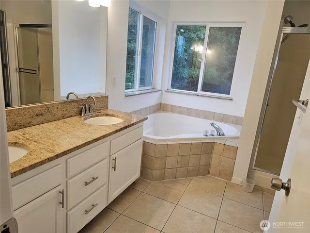a spacious bathroom with a granite countertop sink a toilet and a mirror