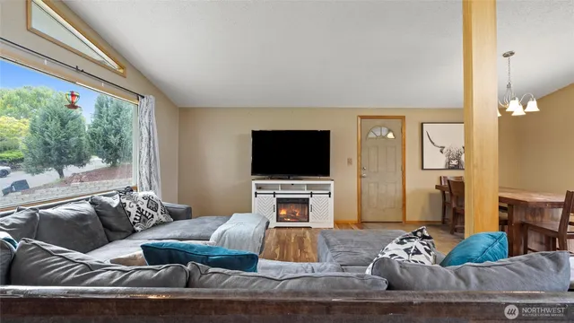 a kitchen with stainless steel appliances granite countertop a refrigerator a sink dishwasher a stove and a flat screen tv