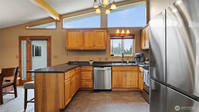 a kitchen with stainless steel appliances granite countertop a refrigerator stove top oven a sink and dishwasher