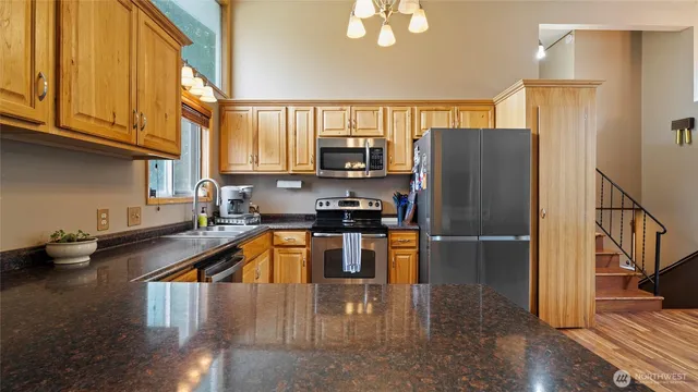 a dining room with wooden floor a chandelier a wooden table and chairs