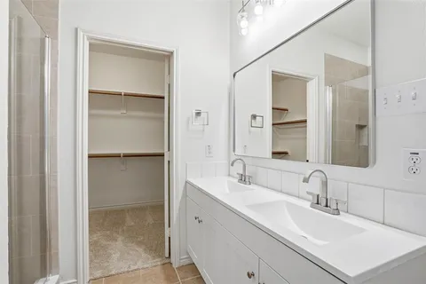 an empty room with a chandelier fan and a ceiling fan