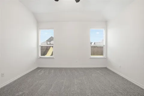 a view of an empty room and chandelier fan