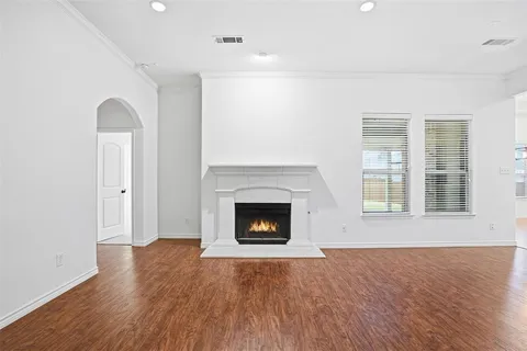 a view of a livingroom with a fireplace a ceiling fan and kitchen view