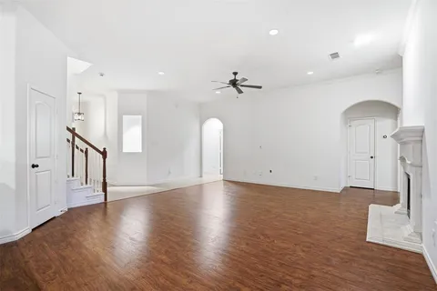a view of a big room with wooden floor and a kitchen