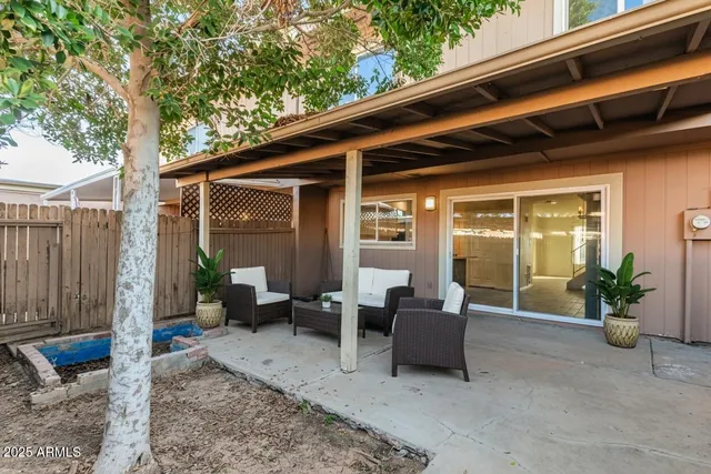 a view of a patio with chairs and potted plants