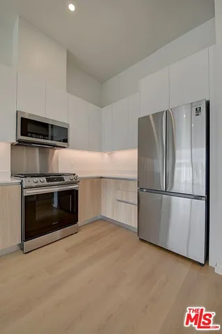 a kitchen with granite countertop a refrigerator and a stove