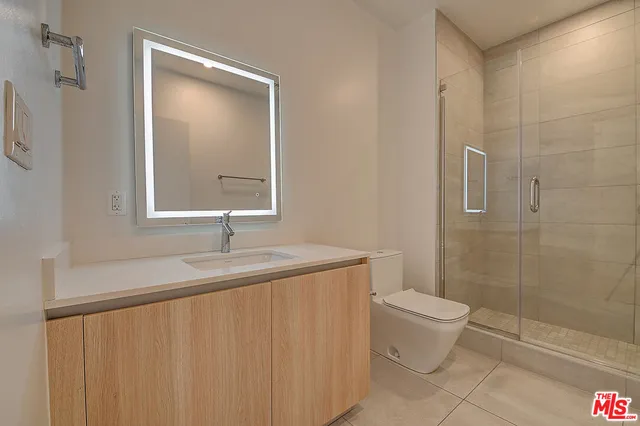a bathroom with a granite countertop sink a toilet and shower