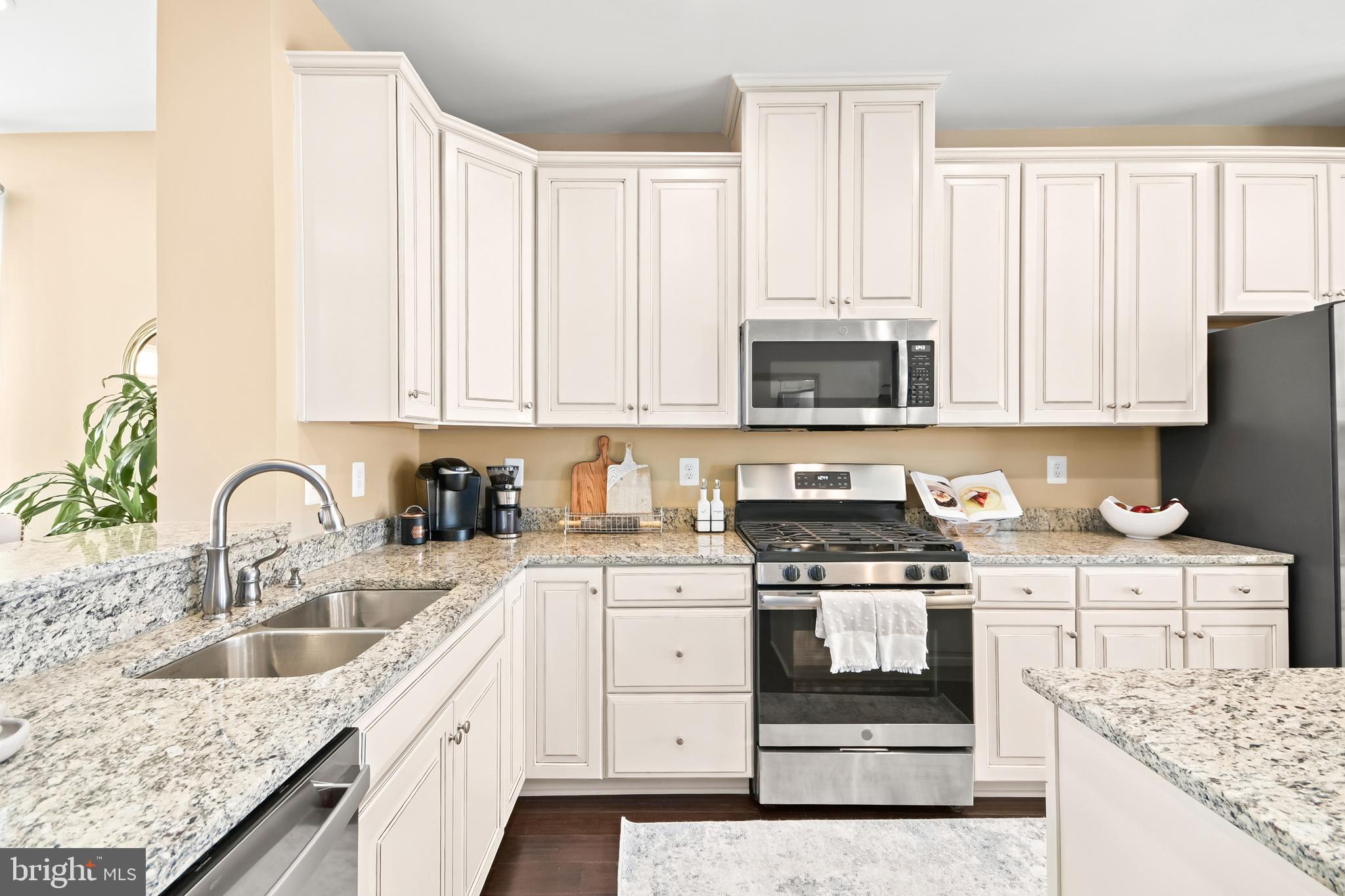 4502 Tinder Monrovia, MD 21770 - Photo 24 of 62 a kitchen with granite countertop a sink stainless steel appliances and white cabinets