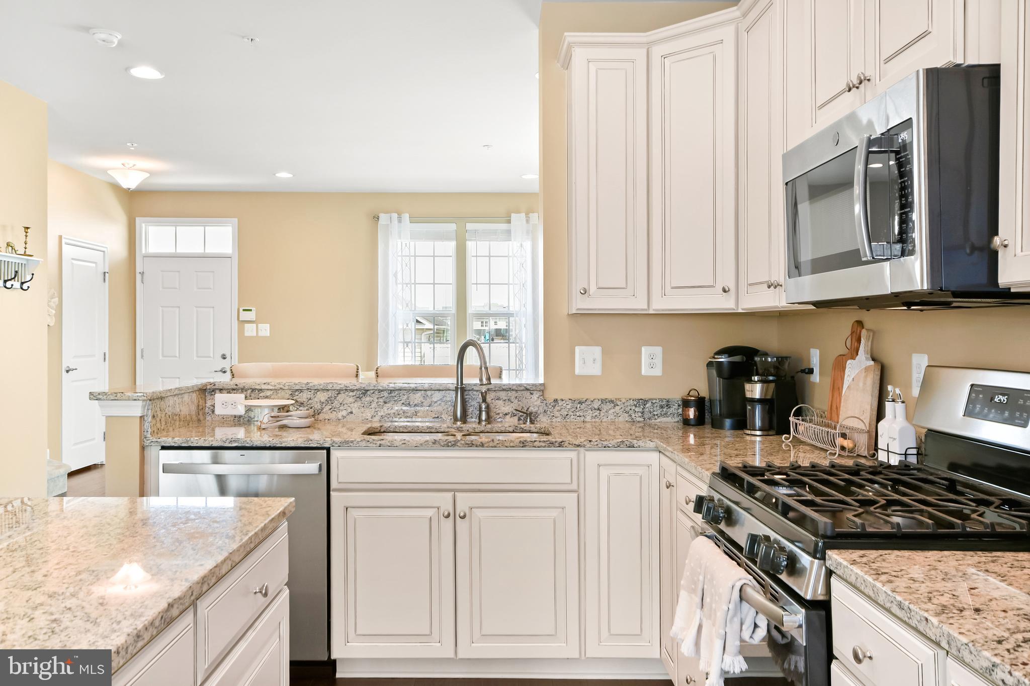 4502 Tinder Monrovia, MD 21770 - Photo 26 of 62 a kitchen with granite countertop a sink stove and cabinets
