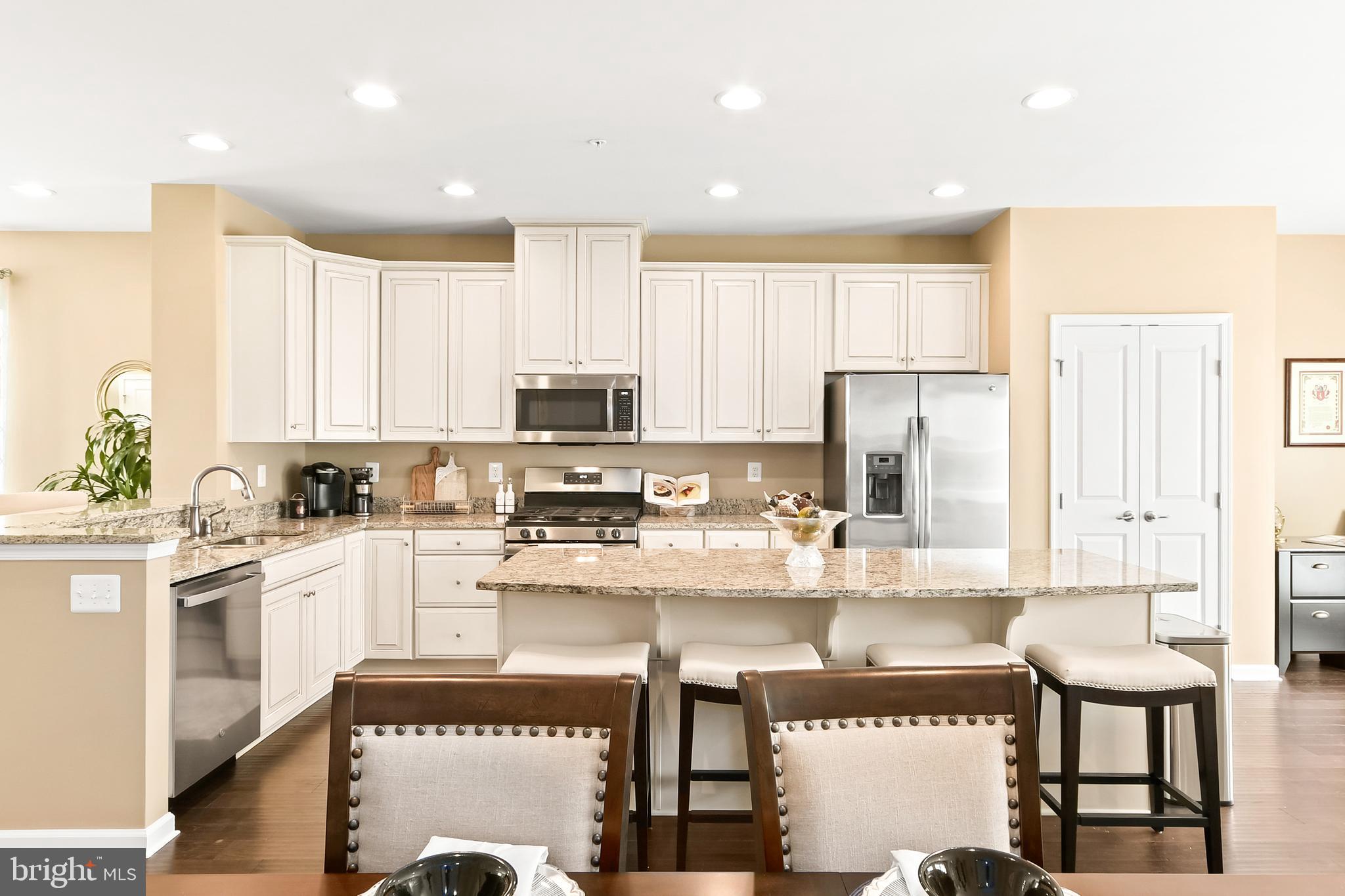 4502 Tinder Monrovia, MD 21770 - Photo 29 of 62 a kitchen with stainless steel appliances granite countertop a stove a sink a microwave a refrigerator and white cabinets with wooden floor
