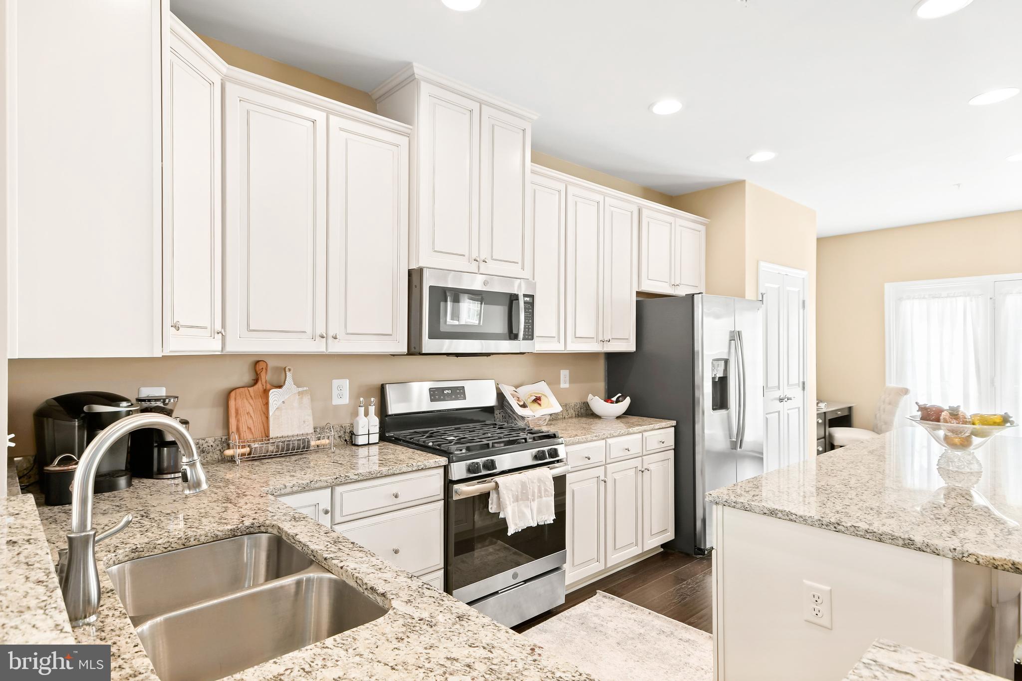 4502 Tinder Monrovia, MD 21770 - Photo 4 of 62 a kitchen with stainless steel appliances granite countertop a sink stove and white cabinets