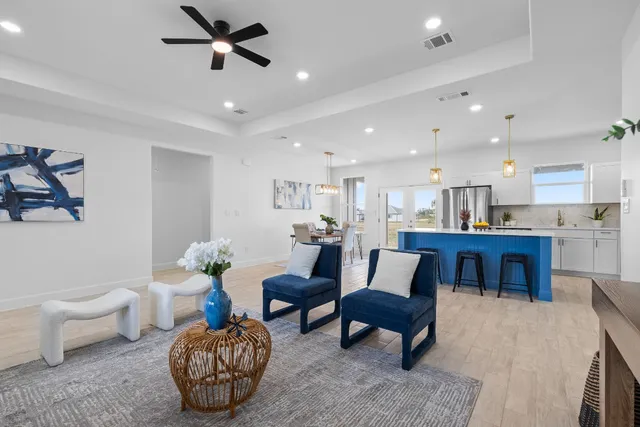 a living room with furniture a rug and kitchen view