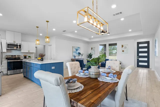 a living room with furniture kitchen view and a chandelier