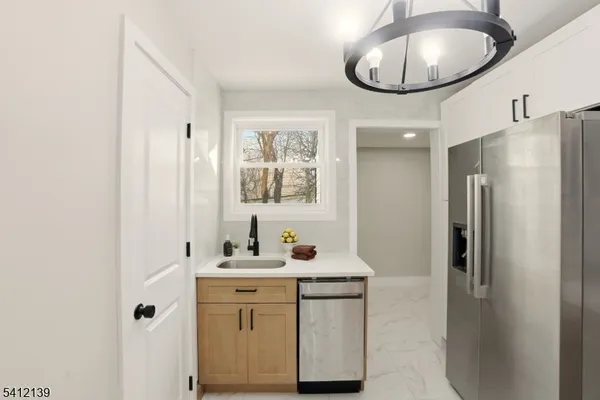 a bathroom with a sink a light fixture and a mirror