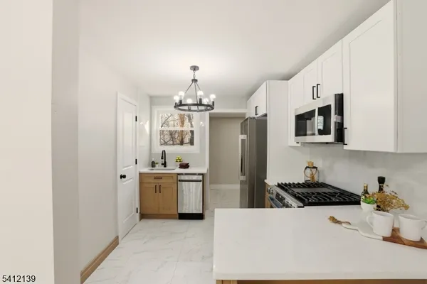 a kitchen with stainless steel appliances a sink stove and refrigerator