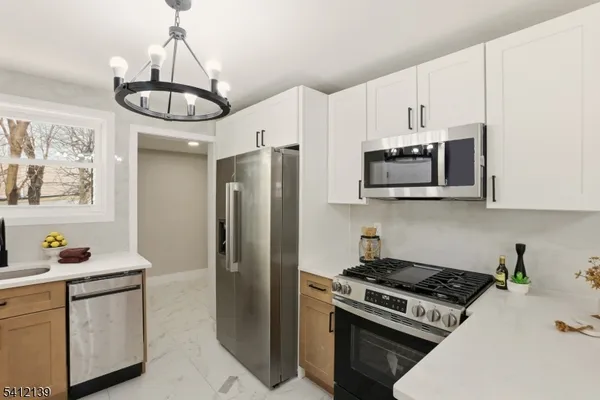 a kitchen with stainless steel appliances a stove a sink and cabinets