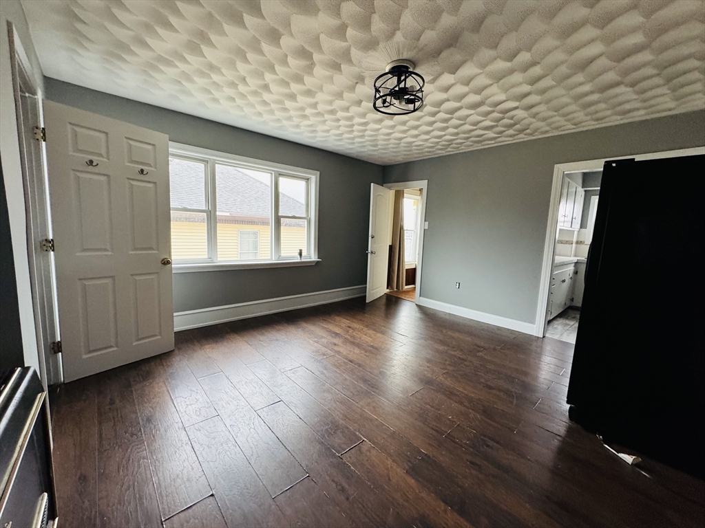 166 Bradford Avenue, Unit 3 Fall River, MA 02721 - Photo 16 of 19 an empty room with wooden floor and windows