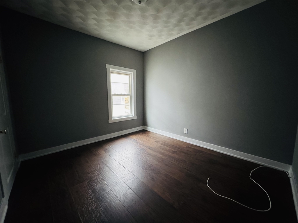 166 Bradford Avenue, Unit 3 Fall River, MA 02721 - Photo 19 of 19 a view of an empty room with wooden floor and a window