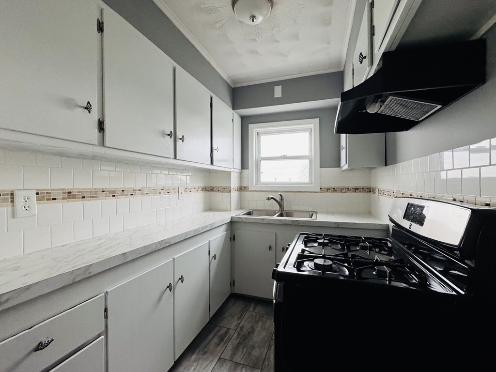 166 Bradford Avenue, Unit 3 Fall River, MA 02721 - Photo 4 of 19 a kitchen with a sink stove and cabinets