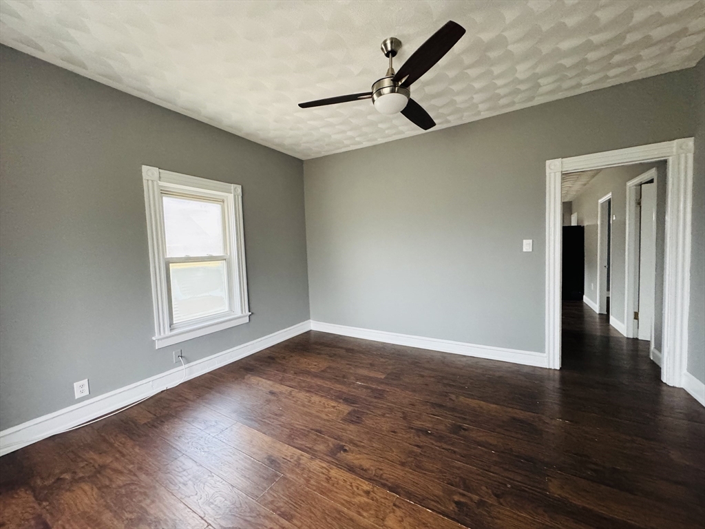 166 Bradford Avenue, Unit 3 Fall River, MA 02721 - Photo 10 of 19 a view of an empty room with wooden floor and a window